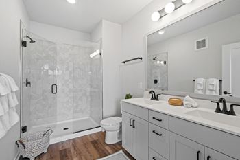 a white bathroom with a shower and a sink
